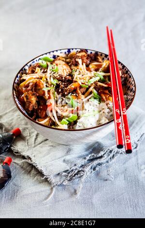 Ciotola con pollo dolce e agrodolce e verdure sul riso Foto Stock