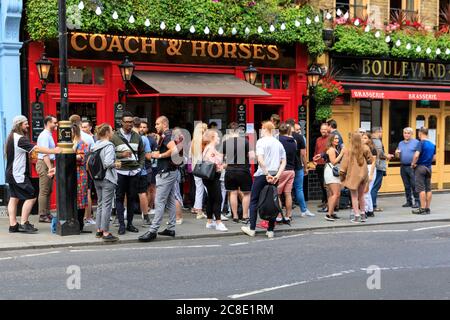 Londra, Regno Unito. 23 luglio 2020. Un numero piuttosto elevato di persone beve e chiacchiera fuori da un pub nella popolare area di Covent Garden a Londra, rendendo la distanza sociale effettivamente impossibile. Credit: Imageplotter/Alamy Live News Foto Stock