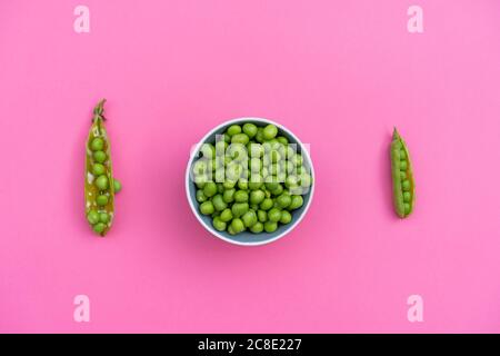 Studio di due cialde di piselli verdi e ciotola di piselli verdi Foto Stock