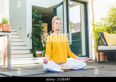 Ritratto di donna matura meditando sulla terrazza Foto Stock