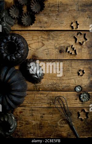 Collezione di vecchi utensili da cucina rustici, tra cui teglie, tagliabiscotti e frusta a filo Foto Stock