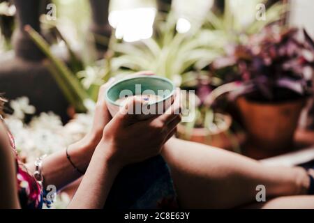 Primo piano delle mani della donna che tengono la tazza di caffè