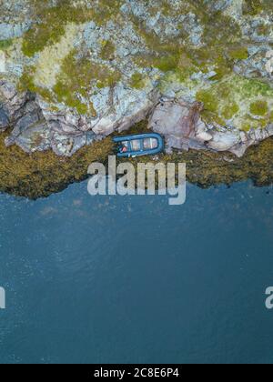 Russia, regione di Murmansk, distretto di Kolsky, Teriberka, Barca sulla costa rocciosa Foto Stock