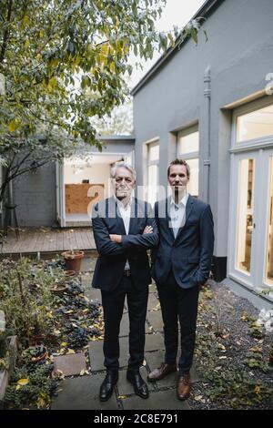 Due uomini d'affari di successo in piedi sul cortile del loro ufficio Foto Stock