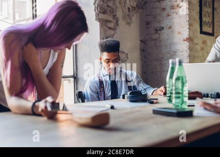 Persone creative che lavorano al tavolo in un ufficio loft Foto Stock