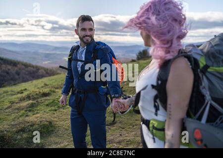 Coppia nuziale con zaini per arrampicata di fronte al monte Urkiola, Spagna Foto Stock