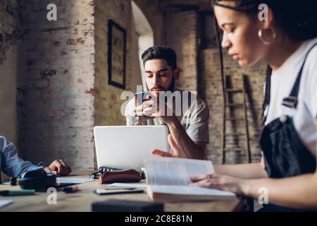 Persone creative che lavorano al tavolo in un ufficio loft Foto Stock