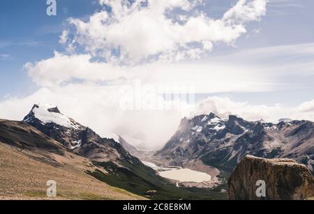 Vista panoramica delle montagne innevate contro il cielo nuvoloso, Patagonia, Argentina Foto Stock