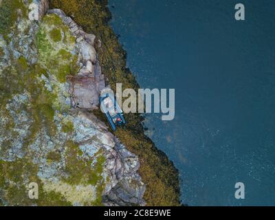 Russia, regione di Murmansk, distretto di Kolsky, Teriberka, Barca sulla costa rocciosa Foto Stock