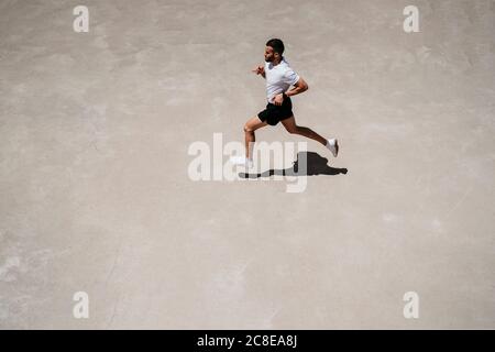 Uomo che corre all'aperto sotto il sole Foto Stock