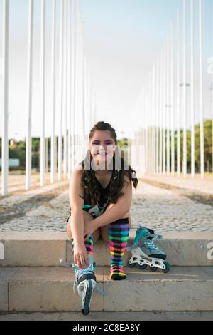 Adolescente ragazza con sindrome di Down che indossa 80s colorful make-up e. pattini a rotelle Foto Stock