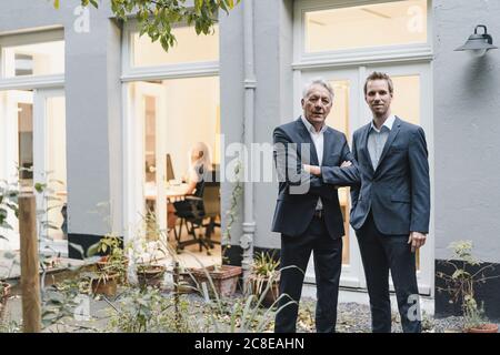 Due uomini d'affari di successo in piedi sul cortile del loro ufficio Foto Stock