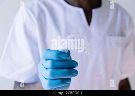 Primo piano di un medico che tiene l'alignatore dentale Foto Stock