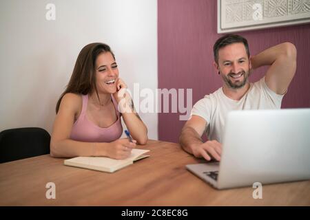 Coppia felice che lavora insieme a casa Foto Stock