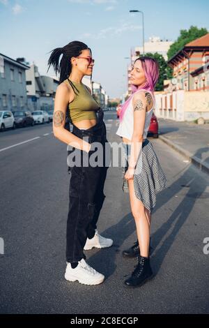 Due giovani donne in piedi per strada in città Foto Stock