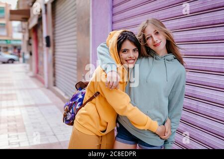 Ritratto di due amiche sorridenti e abbraccianti nel città Foto Stock