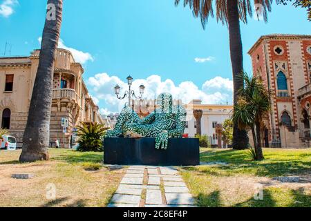 Statua di Rabarama vicino al mare a Reggio Calabria. Centro storico di Reggio Calabria durante una giornata estiva. E' possibile vedere villa genovese Zerbi sul retro Foto Stock