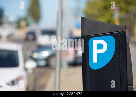 Parcheggio metro o biglietto stazione a pagamento con vetture su strada in sfondo sfocato. Foto Stock