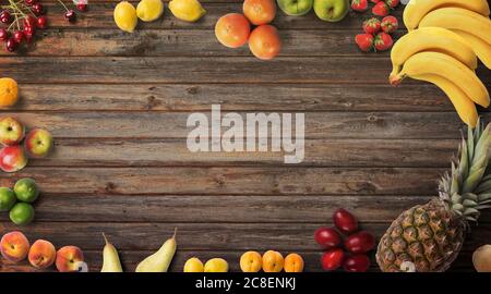 Frutta sfondo. Fotografia alimentare diversi tipi di frutta su sfondo di legno. Spazio di copia. Prodotto isolato ad alta risoluzione. Sfondo colorato Foto Stock