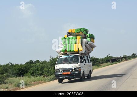 Un furgone per passeggeri sovraccarico, accatastato di bagagli, che viaggia su un'autostrada nella rurale Niger, Africa Foto Stock