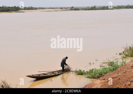 Un pescatore nella sua canoa scavata sulla riva del fiume Niger a Niamey, Niger Foto Stock