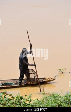 Un pescatore nella sua canoa scavata sulla riva del fiume Niger a Niamey, Niger Foto Stock