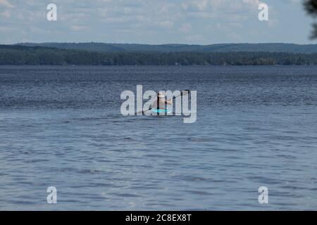 persona in kayak che canta sul lago Foto Stock