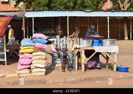 Un venditore di riso e una donna che vende pasti caldi in una strada principale a Niamey, Niger, Africa. Foto Stock