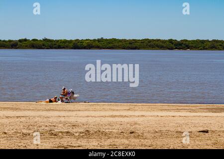 Colon - Entre Rios, ARGENTINA - CIRCA novembre 2017: Vecchia coppia prendere il sole sulla riva del fiume uruguay Foto Stock