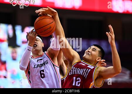 Qingdao, la provincia cinese di Shandong. 24 luglio 2020. Il Tianju (L) di Liaoning Flying Leopards vies con Xing Zhiqiang di Shanxi Loongs durante una partita alla lega 2019-2020 della Chinese Basketball Association (CBA) a Qingdao, nella provincia di Shandong, nella Cina orientale, il 24 luglio 2020. Credit: Yongqiao/Xinhua/Alamy Live News Foto Stock