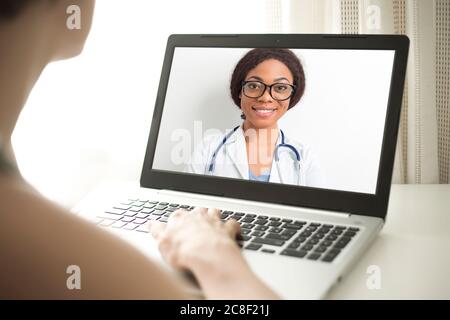 Donna afroamericana medico sullo schermo del portatile consulta un paziente online. Foto Stock