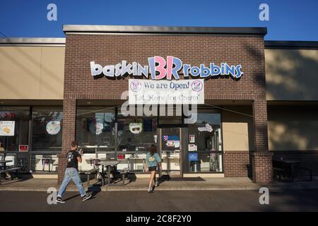 Una giovane coppia ha messo sulle maschere del viso prima di entrare in una gelateria Baskin-Robbins giovedì 22 luglio 2020, durante la pandemia del coronavirus. Foto Stock