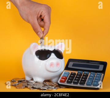 conservazione del capitale in una crisi economica calcolatrice monete di fondo giallo Foto Stock