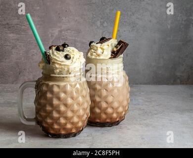 Frullato di cioccolato dolce con gelato, caffè e panna montata in un vasetto di vetro in muretto. Foto Stock