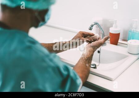 Chirurgo lavarsi le mani prima di operare paziente in ospedale - lavoratore medico preparandosi per la lotta contro la pandemia del virus corona Foto Stock