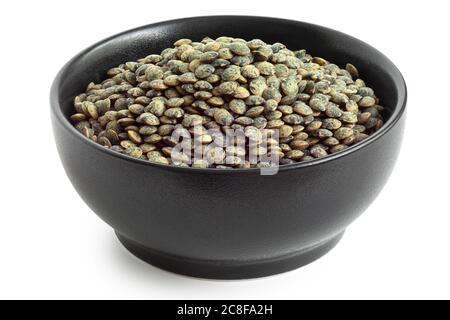 Lenticchie verdi francesi secche puy in ciotola nera in ceramica isolata su bianco. Angolo alto. Foto Stock