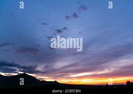 Panorama colorato magnifico tramonto in campagna sopra colline e campi Foto Stock