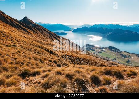 Un lago Wanaka ancora blu in una mattinata invernale nell'Isola del Sud della Nuova Zelanda Foto Stock