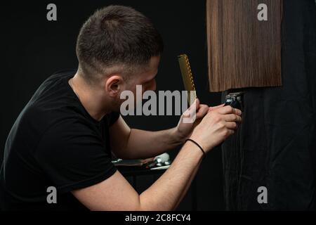 Giovane maschio professionale parrucchiere taglio ragazze brunette capelli Foto Stock