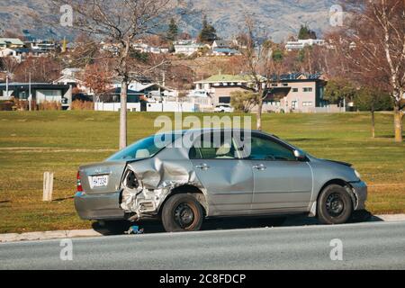 Un'auto distrutta parcheggiata sul lato della strada nella cittadina di Wanaka, in Nuova Zelanda, dopo che si è schiantata e rotolata sopra Foto Stock