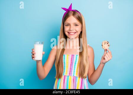 Primo piano-in su ritratto di lei bella attraente grazioso allegro cheery ragazza dai capelli lunghi mangiare biscotti bere eco fattoria latte biologico isolato su Foto Stock