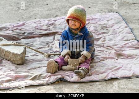 Jhong, Nepal - Novembre 17, 2015: piccolo bambino nepalese giocando sul terreno. Foto Stock