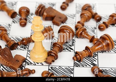 re degli scacchi bianchi circondato da avversari caduti Foto Stock