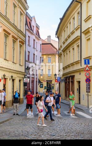 PRAGA - 20 LUGLIO 2019: Turisti che attraversano una traversata di zebra su una vecchia strada acciottolata a Praga, Repubblica Ceca Foto Stock
