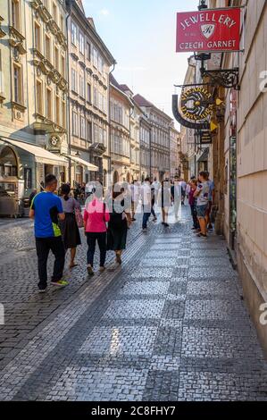 PRAGA - 20 LUGLIO 2019: Immagine verticale di una affollata scena turistica acciottolata tra vecchi negozi a Praga, Repubblica Ceca Foto Stock