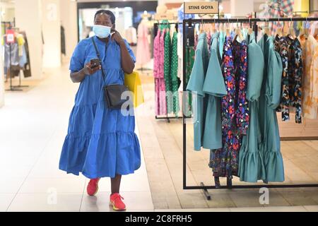 Una donna indossa una maschera mentre cammina attraverso Selfridges a Londra, mentre i rivestimenti del viso diventano obbligatori nei negozi e nei supermercati in Inghilterra. Foto Stock