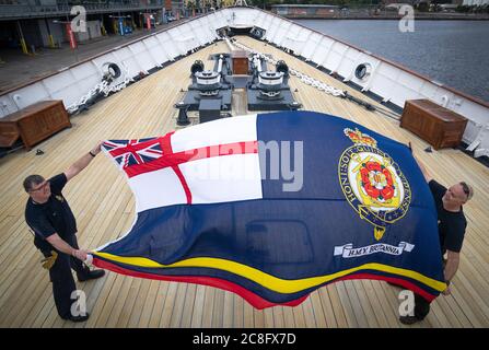 Tony Smith (a sinistra) e Rab McAulay del team di manutenzione si preparano ad alzare la bandiera Britannia sul Royal Yacht Britannia per segnare la riapertura dell'attrazione turistica di Edimburgo ai membri del pubblico lunedì 27 luglio. Foto Stock