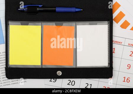 organizer con note vuote su calendario e grafici Foto Stock