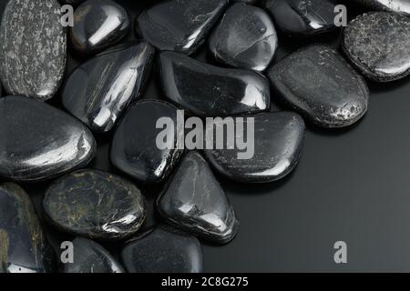 pietre nere lisce su superficie nera Foto Stock