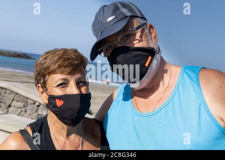 Costa Adeje, Tenerife, Isole Canarie, Spagna. 24 luglio 2020. Turisti che indossano maschere di fronte come vanno alla spiaggia di Playa Fanabe, come Tenerife riapre al turismo con forti controlli di igiene contro Covid 19. Foto Stock